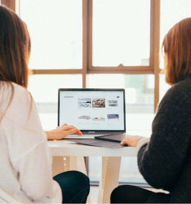 two persons collaborating at a laptop